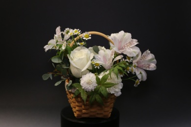 放在黑盒子上的白色插花小花篮