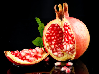 黑底上放着掰开的突尼斯软籽石榴 