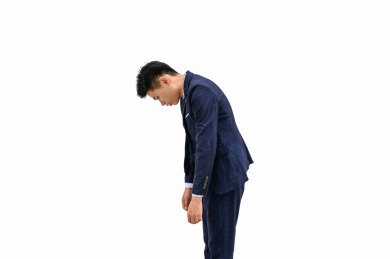 白色背景前弯腰低头的商务男性