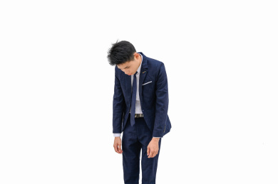 白色背景前弯腰低头的商务男性