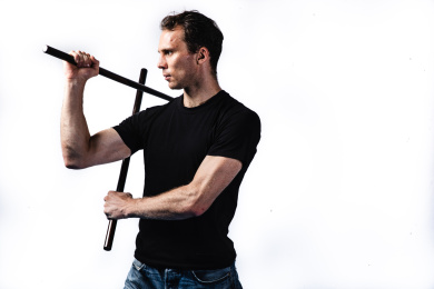 白色背景白人男性拿着藤棍在练习武术