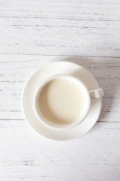 白色木纹桌面上的一杯牛奶