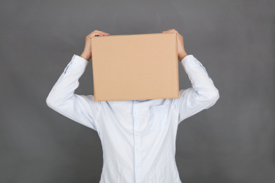 头戴纸箱子的人在灰背景前