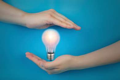 蓝背景上的手和灯泡