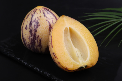 放在黑色背景盘子里切来的人生果