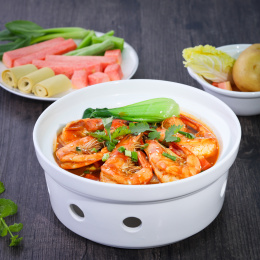 放在木纹背景上碗里的海鲜大虾鸡公煲