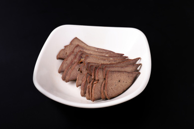 放在黑色背景上碟子里的猪肝