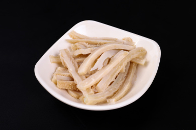 放在黑色背景上碟子里的切丝的毛肚