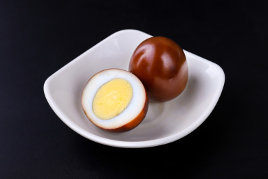 放在黑色背景上碟子里的卤蛋