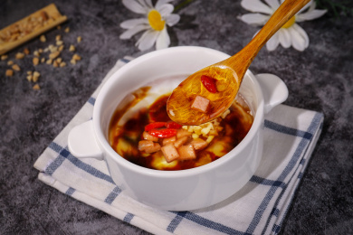 放在黑色背景方格餐布上碗里的冰粉