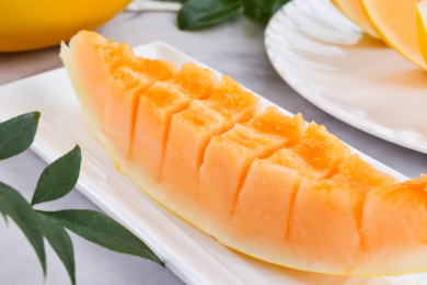 放在大理石背景盘子里切开的黄河蜜瓜