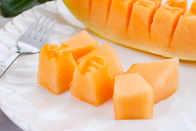 放在大理石背景上盘子里切块的蜜瓜果肉