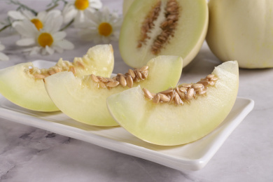 放在大理石背景上盘子里切开的阎良甜瓜