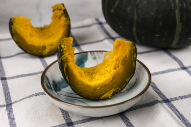 方格餐布上小碟子里蒸熟切开的贝贝南瓜