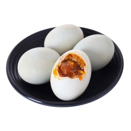 放在白背景上盘子里剥开的咸鸭蛋