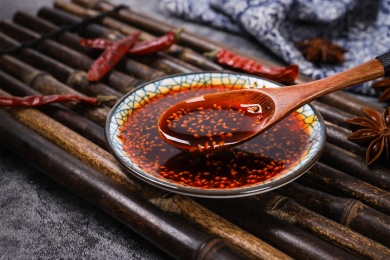 放在竹排上碟子里用勺子舀起来的辣椒油