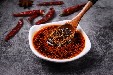 放在深色背景上碟子里用勺子舀起来的辣椒油