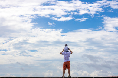 蓝天白云下爸爸和孩子在一起玩