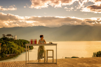 黄昏时分一个女人坐在云南大理洱海边看风景