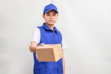 白色背景前拿着包裹的快递配送员