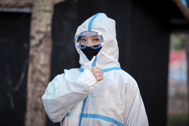 穿白色防护服佩戴护目镜口罩的女性防护人员
