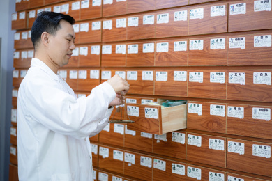 中年男性药剂师在药铺里称取中药