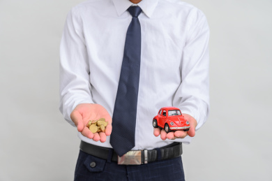 拿着小汽车和硬币的商务人士