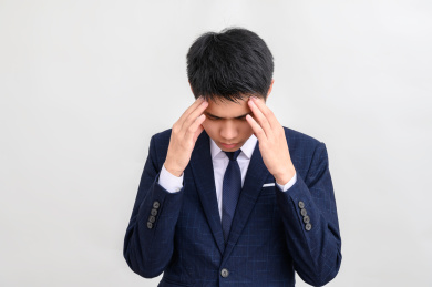 白色背景前头痛的年轻商务男性