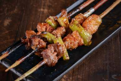 红柳串烤牛肉放在黑色盘子上