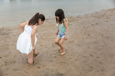 小女孩帮助姐姐拔出陷入淤泥中的脚