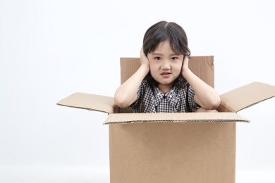 躲在纸箱中调皮可爱的亚洲小女孩