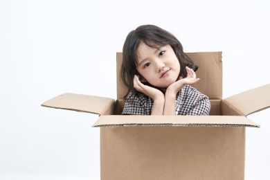 躲在纸箱中调皮可爱的亚洲小女孩