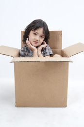 躲在纸箱中调皮可爱的亚洲小女孩