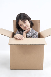 躲在纸箱中调皮可爱的亚洲小女孩