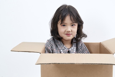 躲在纸箱中调皮可爱的亚洲小女孩