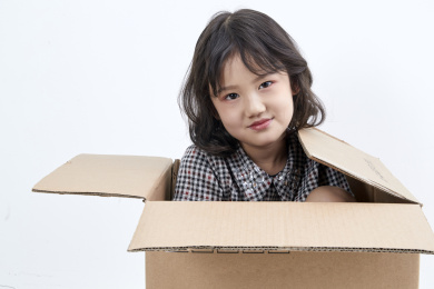 躲在纸箱中调皮可爱的亚洲小女孩
