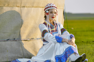 草原上穿着蒙古族传统服饰的亚洲年轻女性