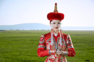 草原上穿着蒙古族传统服饰的亚洲年轻女性