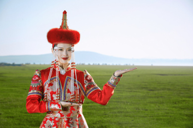 草原上穿着蒙古族传统服饰的亚洲年轻女性