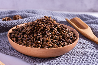 白色桌面上的木盘子里的新鲜的小麦茶