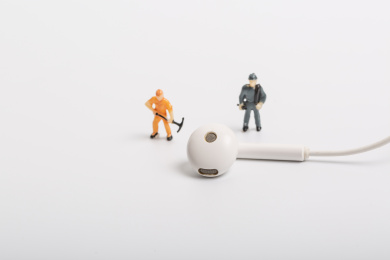 白色背景上的耳机和微缩工人