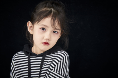 黑色背景的调皮可爱的亚洲小女孩（儿童）