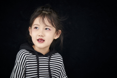 黑色背景的调皮可爱的亚洲小女孩（儿童）