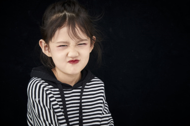 黑色背景的调皮可爱的亚洲小女孩（儿童）