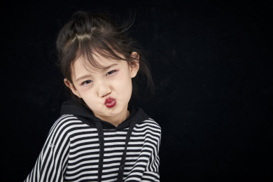 黑色背景的调皮可爱的亚洲小女孩（儿童）