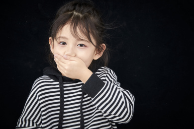黑色背景的调皮可爱的亚洲小女孩（儿童）