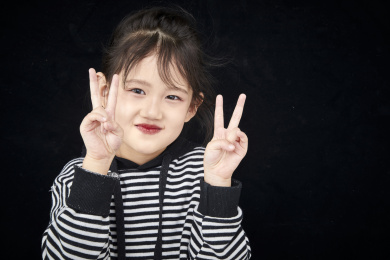 黑色背景的调皮可爱的亚洲小女孩（儿童）