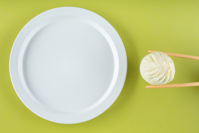 筷子夹走盘中的食物，光盘行动创意图片。