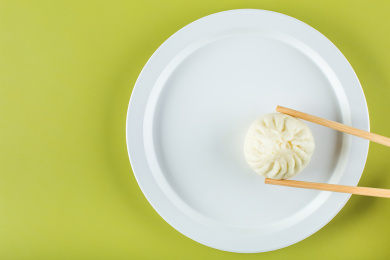 筷子夹走盘中的食物，光盘行动创意图片。