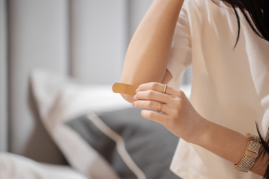 正在给肘关节贴创可贴的女孩